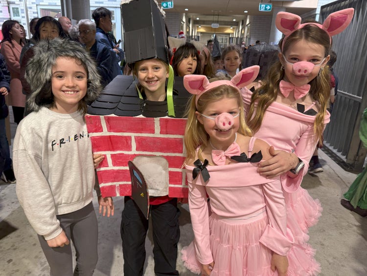 Students dressed as the three little pigs, wolf and brick house
